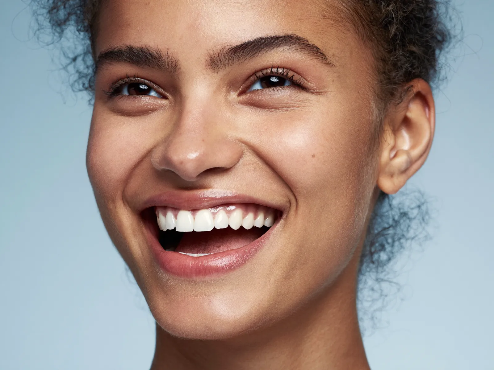 A laughing woman with a bright, healthy smile